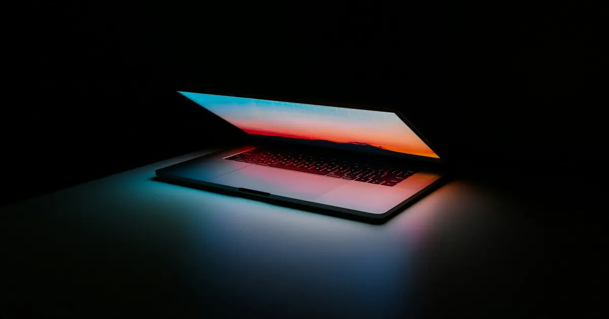 MacBook in low light with a dark screen