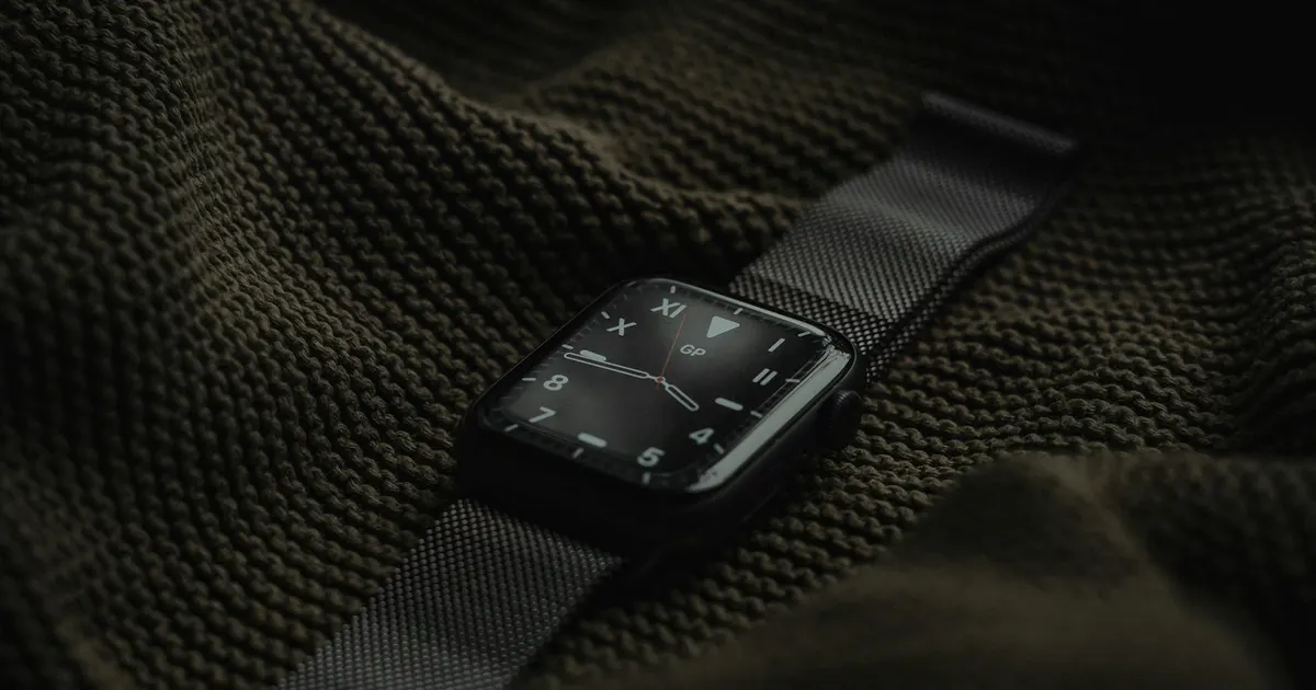 Apple Watch with dark strap on textured fabric