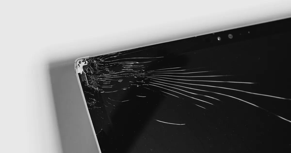 Laptop with a shattered display corner awaiting screen repair