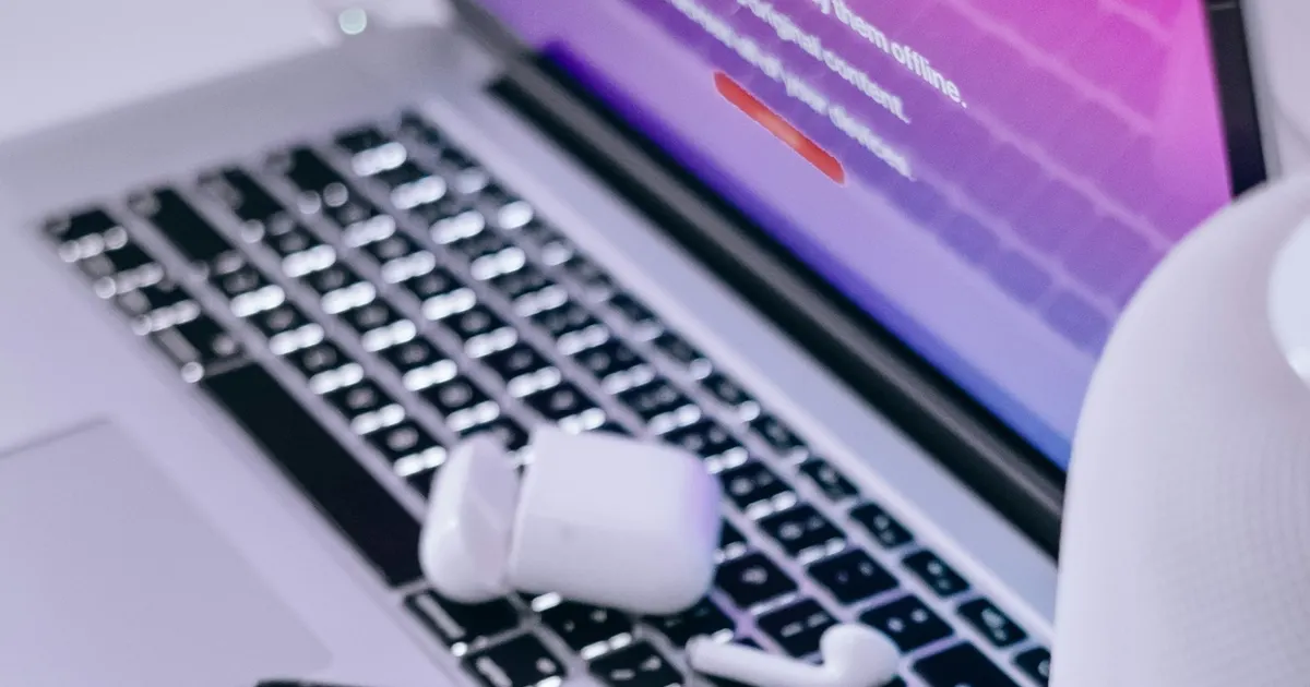 iPhone resting on a MacBook keyboard — Apple devices repaired at iFix Nagaon